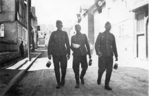 Drei in Ebersgöns einquartierte deutsche Soldaten mit ihrem Kochgeschirr zum Essenempfang (1940).