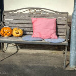 Bild zeigt zwei Halloweenkürbisse auf einer Bank